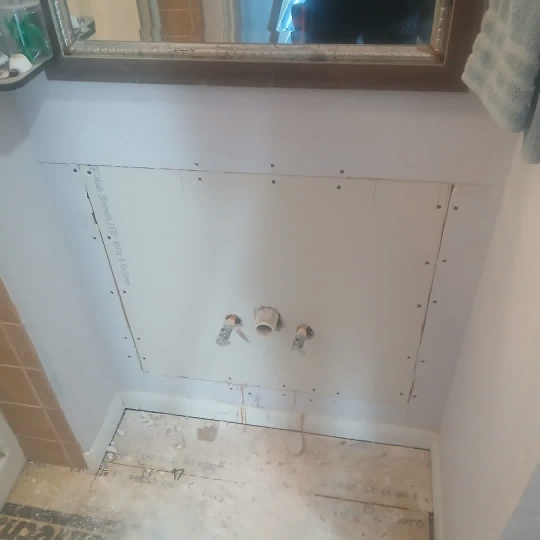 Bathroom wall opened for shower plumbing rough-in