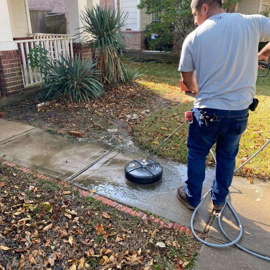 Power washing a sidewalk in a front yard